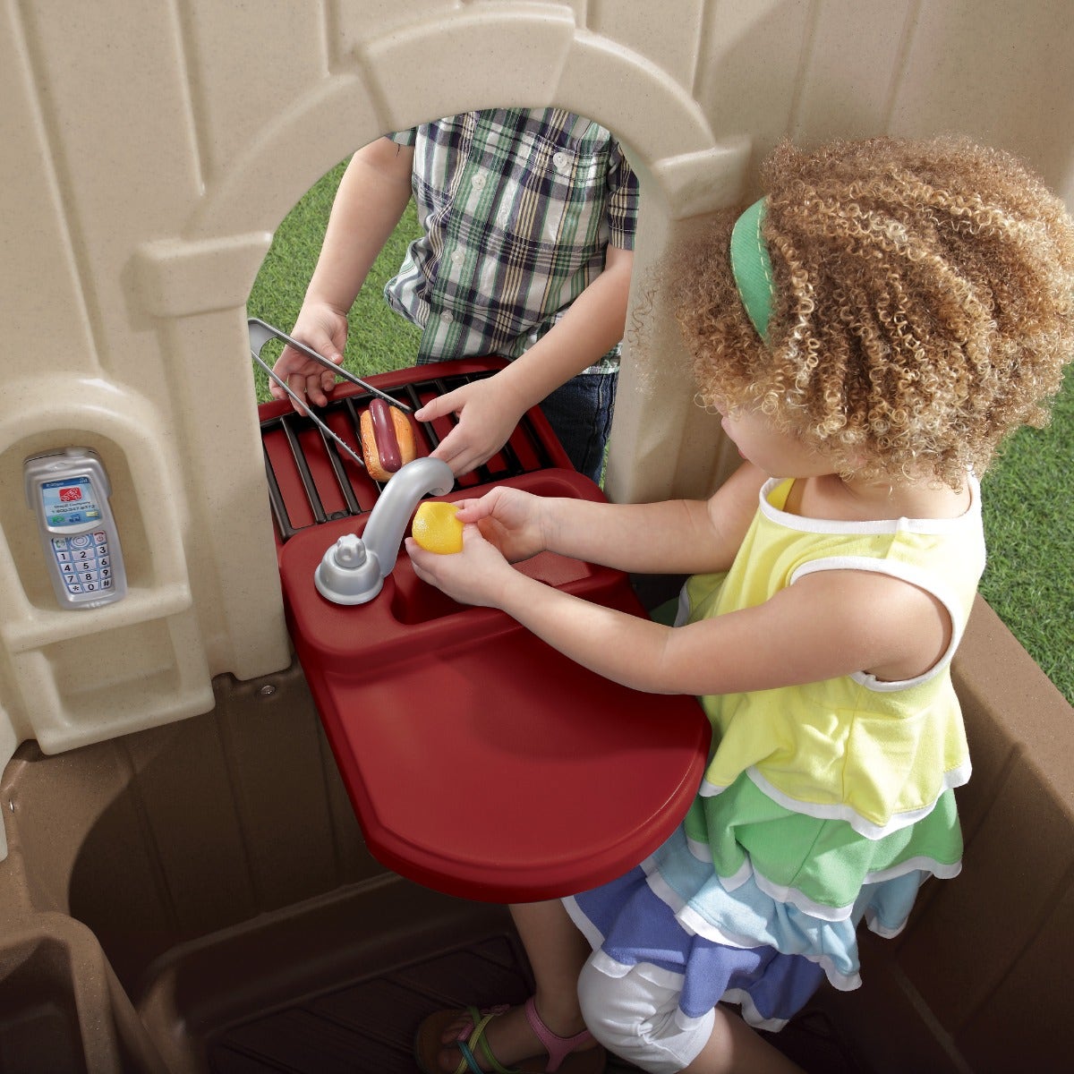 Happy Home Cottage & Grill™ with children using pretend sink and grill