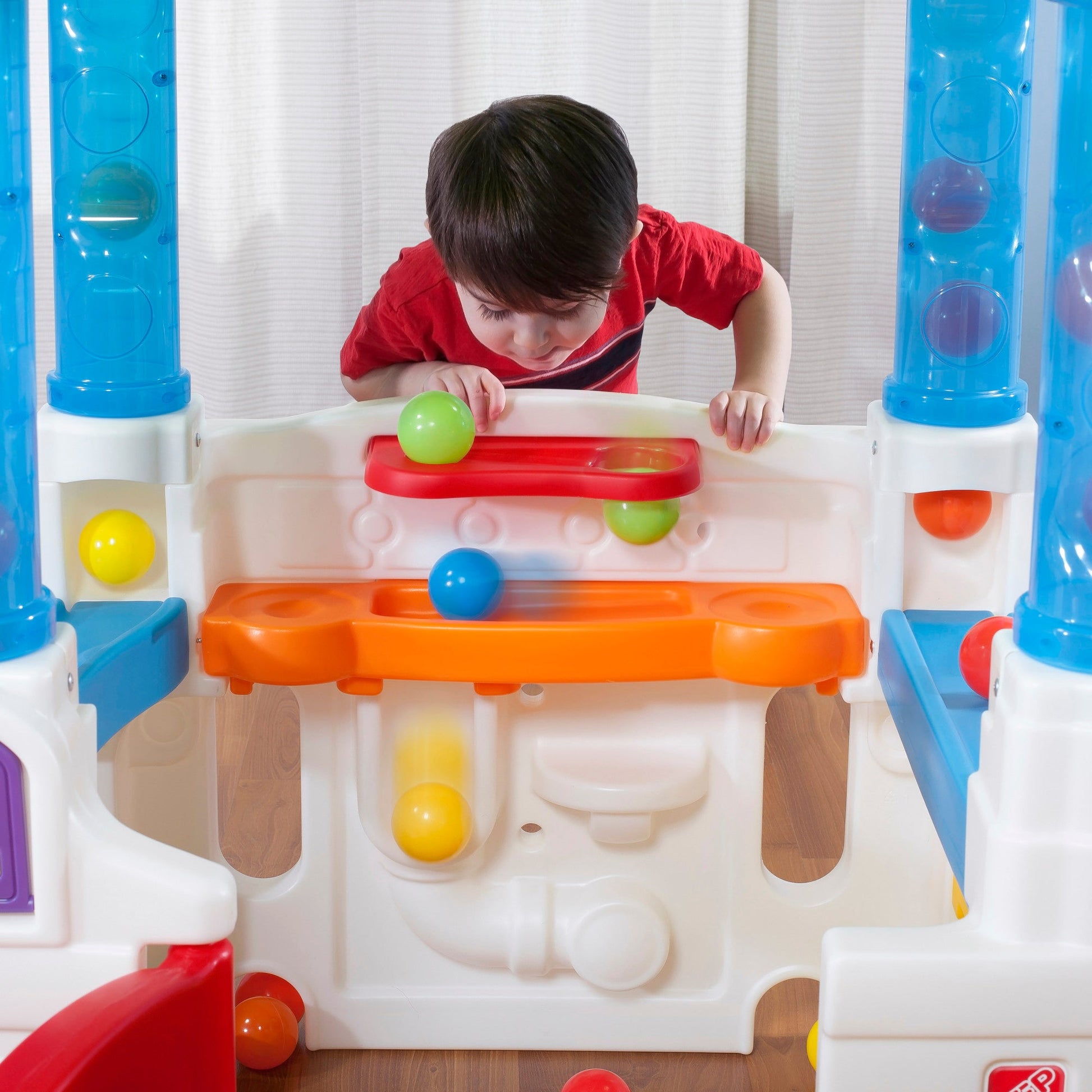 WonderBall Fun House™ child dropping ball through holes