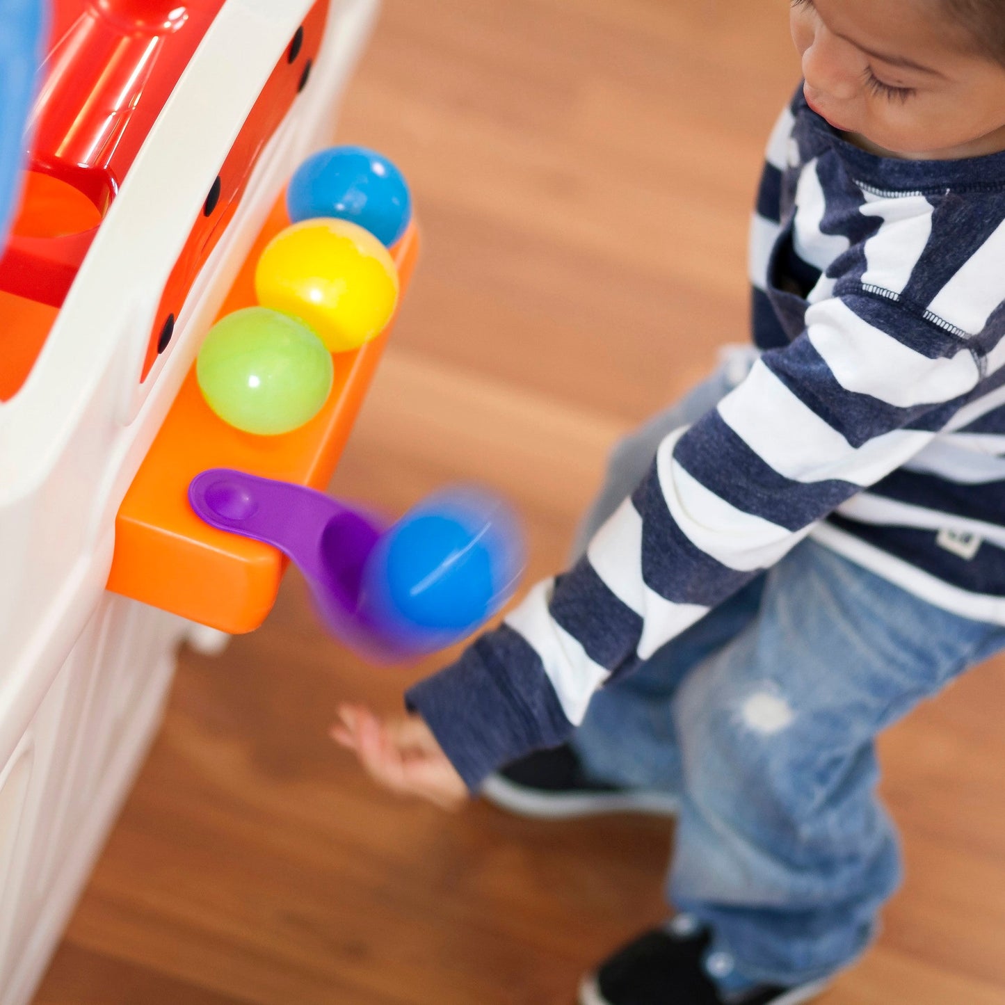 WonderBall Fun House™ child playing with flipper station
