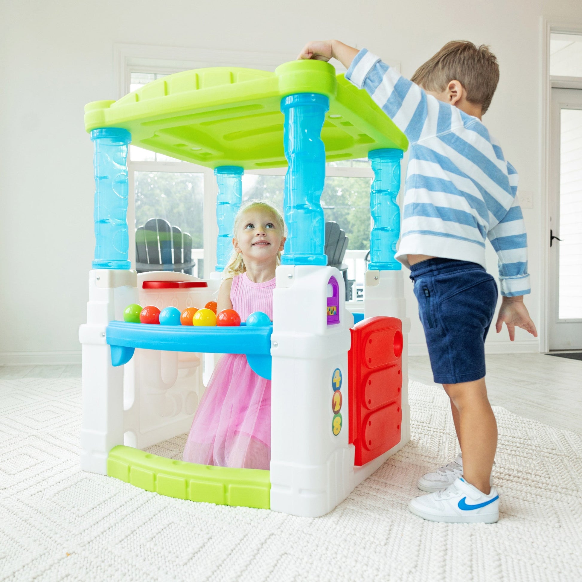 WonderBall Fun House™child putting ball on roof to go down maze